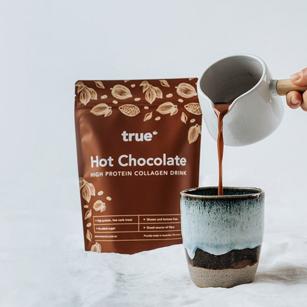 True Hot Chocolate high-protein collagen drink pouch with ceramic mug being poured, premium Australian-made protein hot chocolate beverage product image