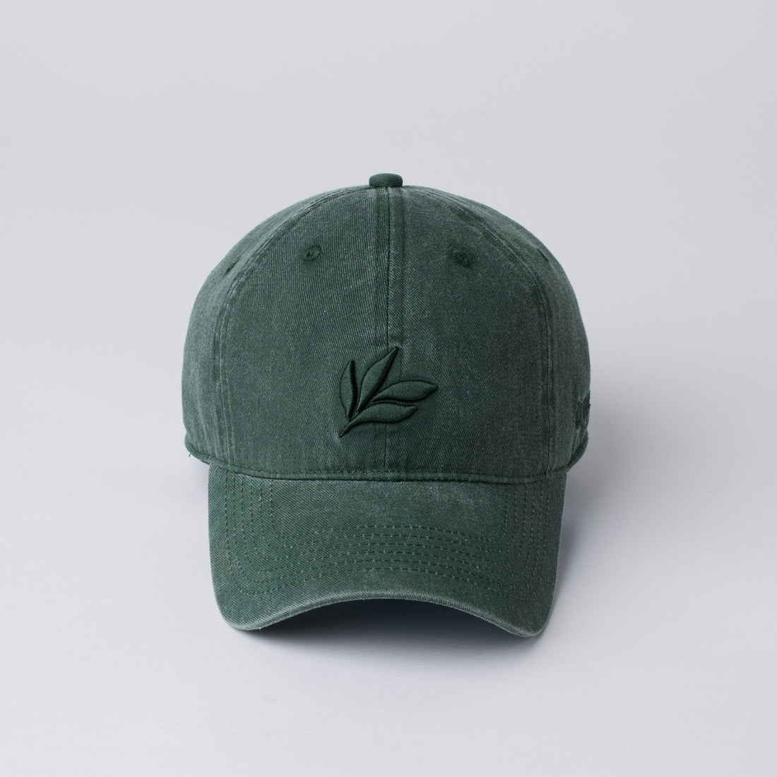 Forest green relaxed-fit cotton baseball cap with curved brim and embroidered leaf logo, front view, adjustable back—outdoor casual hat for men and women.